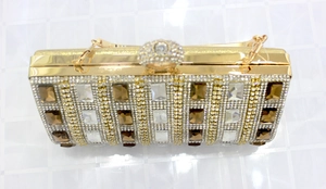 Detailed top view of gold evening clutch bag with brown crystals and rhinestone clasp