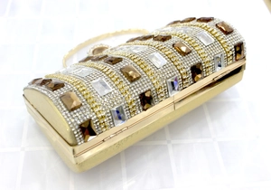 Close-up of luxury gold evening clutch bag with sparkling crystals and metal chain