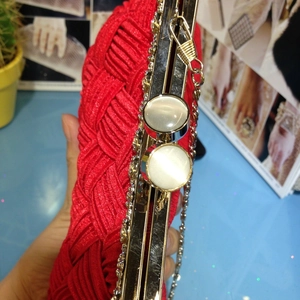 Red woven bridal clutch bag with gold metal frame and oversized white gem clasp detail