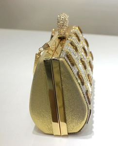 Macro detail of gold evening clutch bag featuring amber crystals and sparkling rhinestones