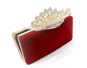 Detail der roten Samt-Abendtasche mit einem mit Strass besetzten goldenen Pfauenverschluss