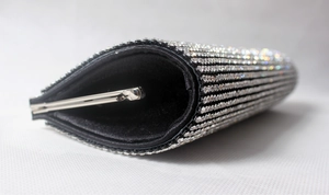 Detail view of the black evening clutch featuring silver rhinestones and satin lining