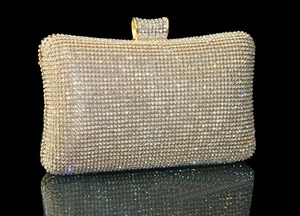 Détail macro des strass blancs étincelants sur la pochette de soirée dorée avec fermoir