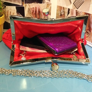 Red satin pleated evening clutch bag with silver chain strap and metal frame