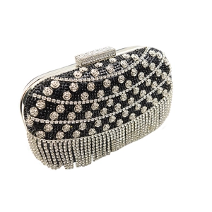 Détail d'une pochette de soirée noire avec rose en strass argentés et franges brillantes