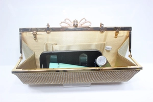 Interior view of gold rhinestone evening clutch showing phone and makeup capacity