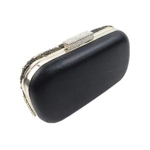 Détail d'une pochette de soirée en satin noir avec strass brillants et fermoir en cristal