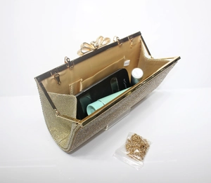 Detailed interior of gold rhinestone evening bag showing champagne lining and chain strap