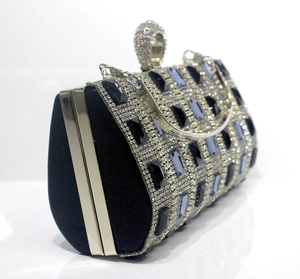 Macro view of crystal encrusted black evening clutch bag with blue rhinestone embellishments