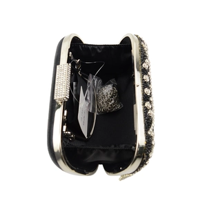 Détail d'une pochette de soirée noire avec fleurs en strass et chaîne en métal argenté