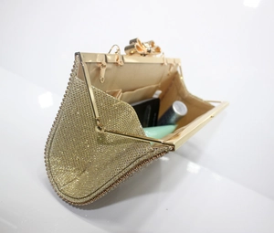 Detailed interior view of a gold rhinestone evening clutch with crystal bow clasp