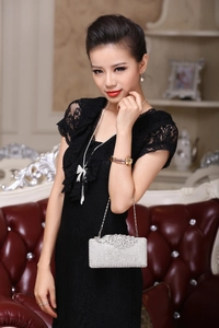 Detailed view of luxury peacock diamond evening clutch paired with black lace gown