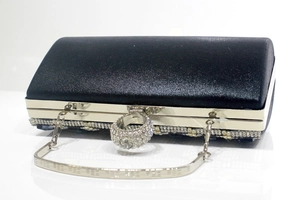 Detail of silver ring clasp with white rhinestones on black satin evening clutch bag