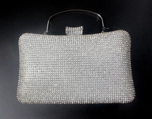 Détail d'une pochette de soirée argentée avec strass et poignée en métal cristallisé