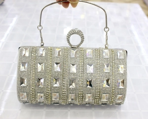 Detail of silver cylindrical evening bag with rhinestones and ring handle clasp