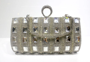 Close-up of luxury silver evening clutch featuring large rectangular crystals and ring handle