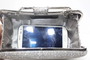 Détails de l'intérieur d'une pochette de soirée argentée en strass avec satin