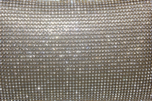 Détail macro de strass étincelants sur un sac de soirée luxueux en maille dorée