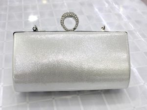 Close-up of silver sequin evening clutch bag with sparkling rhinestone ring clasp
