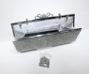 Macro shot of silver sequined clutch bag with diamond bow clasp and interior chain