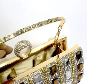 Detail of evening clutch featuring ring-shaped clasp and sparkling rhinestone crystals