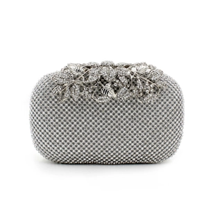 Macro shot of silver evening clutch with leaf-shaped clasp and full rhinestone surface