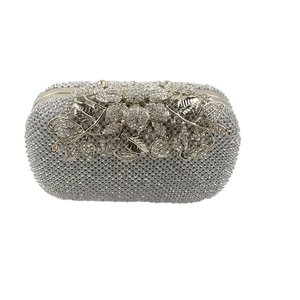 Close-up of luxury leaf-shaped diamond clasp and sparkling rhinestones on evening bag