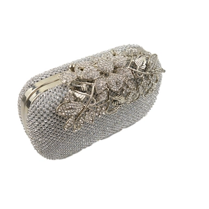 Detailed view of silver evening bag with rhinestone leaves and sparkling diamond crystals