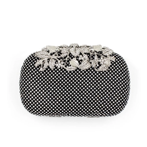 Close-up of elegant silver leaf clasp with inlaid diamonds on black crystal evening clutch