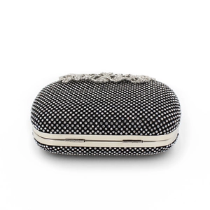 Macro detail of black evening clutch with leaf diamond clasp and crystal grid texture