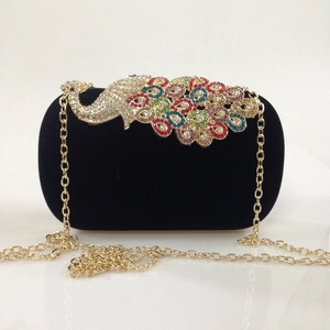 Detailed close-up of a velvet evening clutch featuring a colorful rhinestone peacock pattern
