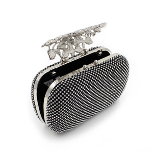 Detail of luxury black clutch bag with silver rhinestone leaf clasp and metal finish