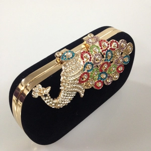 Detail view of colorful peacock rhinestone embellishment on a black velvet clutch bag