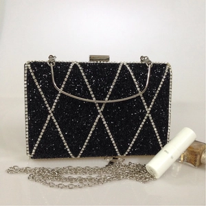 Detail of black evening clutch with silver rhinestone diamond pattern and metal handle