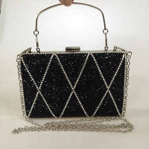Close-up of black evening clutch bag with sparkling silver rhinestone lattice pattern