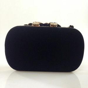 Macro shot of luxury black velvet evening clutch bag with ornate jeweled metal clasp