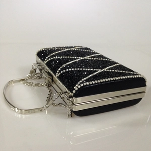 Macro view of rectangular black evening clutch with silver diamonds and chain