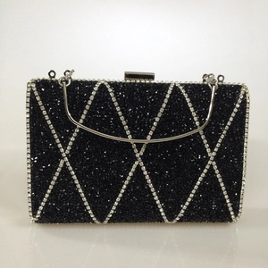 Macro view of black evening clutch with silver rhinestone diamond grid and metal handle
