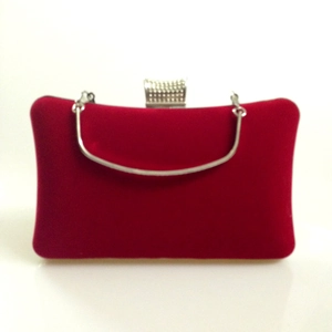 Detail of red velvet evening bag with silver metal handle and rhinestone buckle