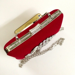 Detail view of red velvet evening bag with silver diamond clasp and detachable chain strap