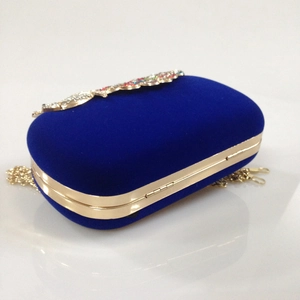 Macro shot of royal blue velvet clutch featuring gold metal frame and crystal decoration
