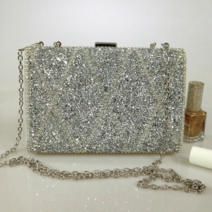 Macro view of silver crystal rhinestone evening clutch with geometric diamond pattern texture