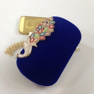 Detail of royal blue velvet peacock evening clutch with colorful rhinestones and chain