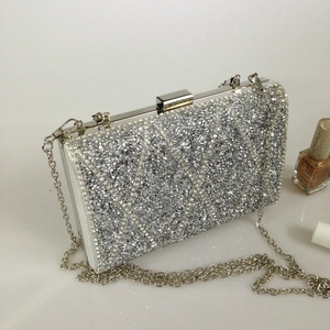 Detailed view of silver rhinestone evening clutch with fine geometric sparkling crystal texture