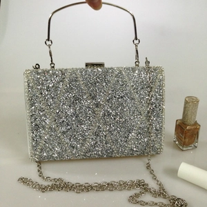 Detail of silver rhinestone evening bag featuring diamond mesh pattern and metal top handle