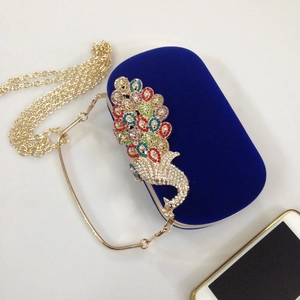 Detail of velvet clutch bag with luxury crystal peacock pattern and gold chain