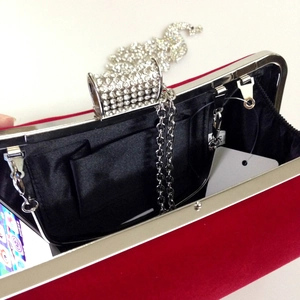 Internal view of red velvet evening bag showing inner pocket, lining, and storage capacity