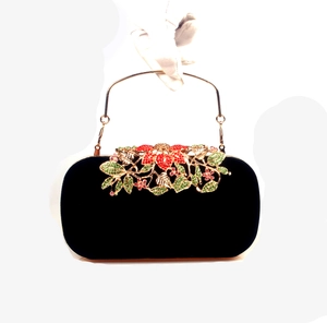 Detailed view of colorful rhinestone floral crystal inlay on a black velvet clutch bag