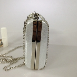 Silver glitter clutch bag with metal frame and delicate chain strap for evening parties