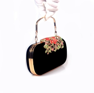 Macro detail of luxury black velvet clutch with colorful crystal flower decoration
